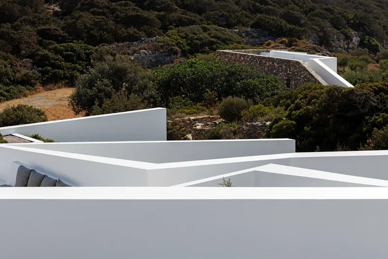 Overlapping white rooflines cascading down the hillside amid native vegetation