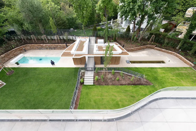 Aerial view of terraced lawn and pool areas with timber stairs descending through planted beds