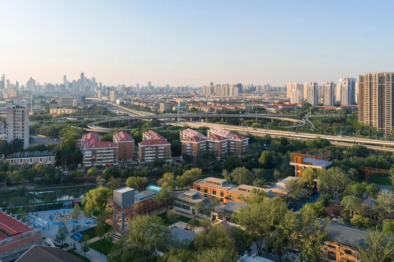 Drone view of the campus with planted grounds and surrounding residential towers at dusk