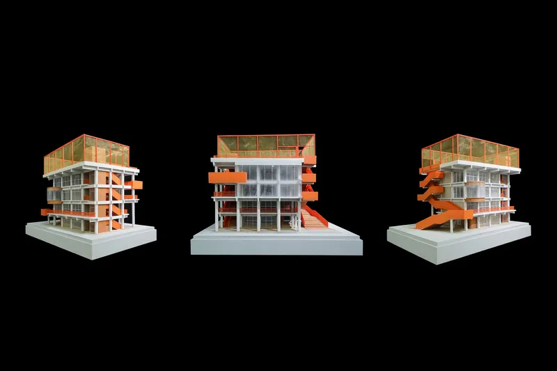 Three views of the physical model with orange external stairs wrapping the structural frame