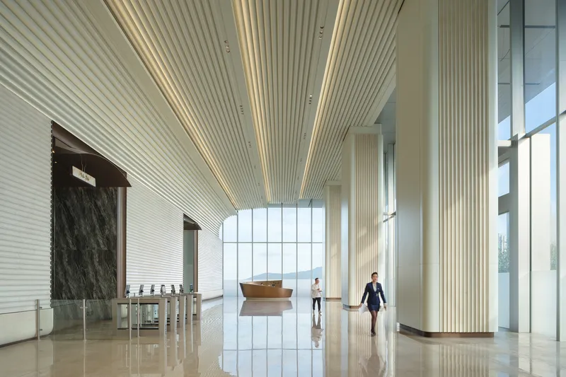 Lobby interior with ribbed ceiling, dark marble wall and two people walking on polished floor