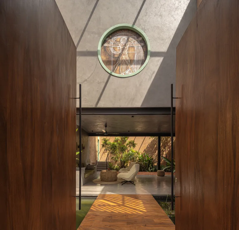 View through timber-clad corridor toward courtyard with circular stained glass window above