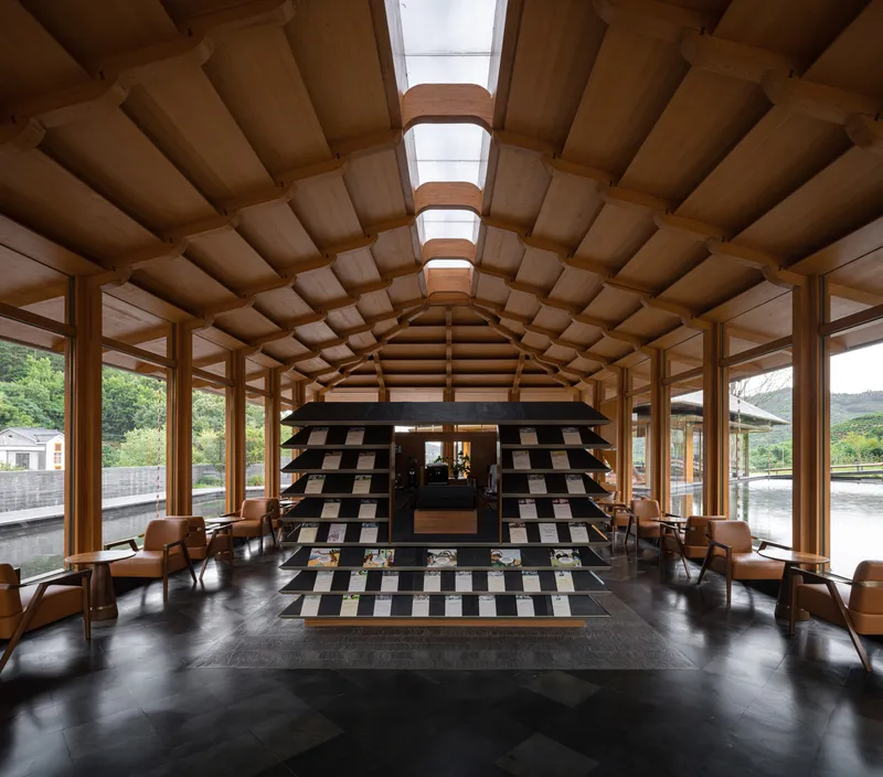 Interior hall with barrel-vaulted timber ceiling, skylights, and chequered black and white tile feature wall