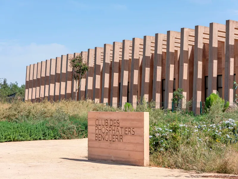 Vertical timber fin screen wrapping the facade with wildflowers and grasses in the foreground