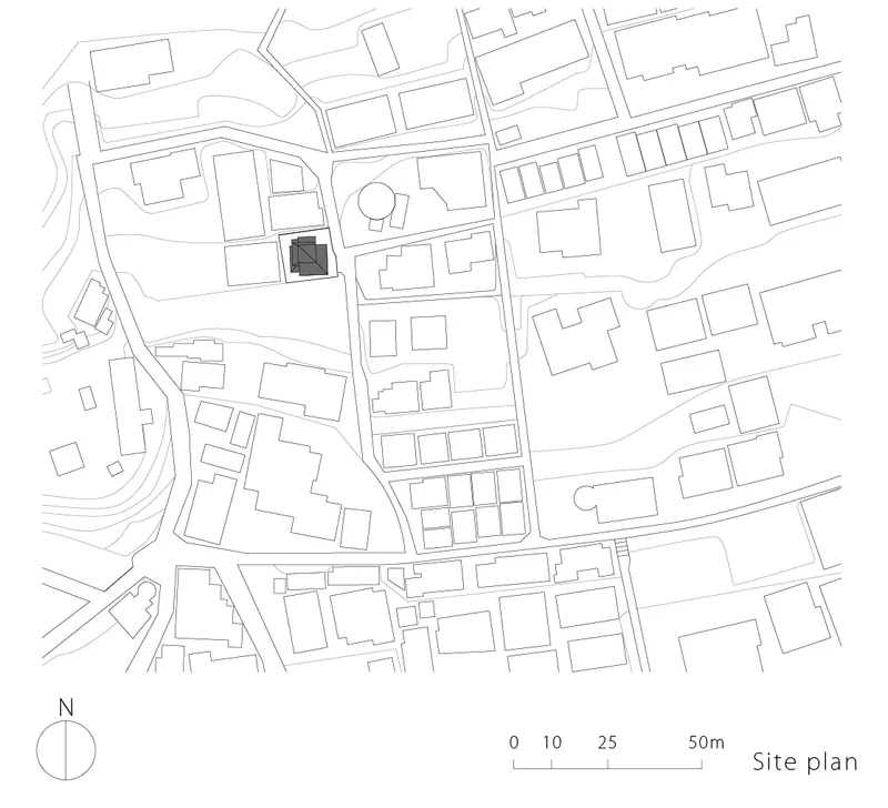 Site plan drawing showing the building footprint within a dense urban block with surrounding streets and structures