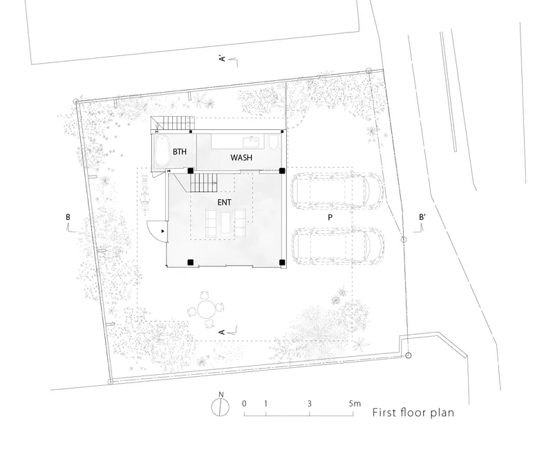 First floor plan drawing showing entry, bathroom, and wash areas surrounded by landscaping and parking spaces