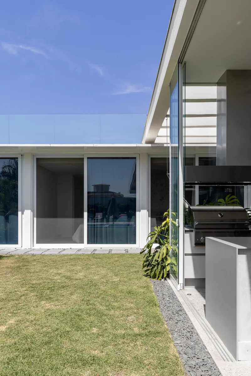 Exterior view of the glass sliding doors opening to the lawn from the covered terrace