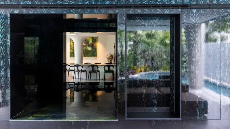 Sliding glass doors with perforated metal screens opening from the terrace to the dining room
