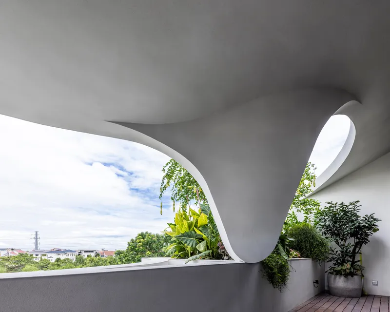 Curved terrace opening with planted pots and timber decking overlooking the neighborhood skyline
