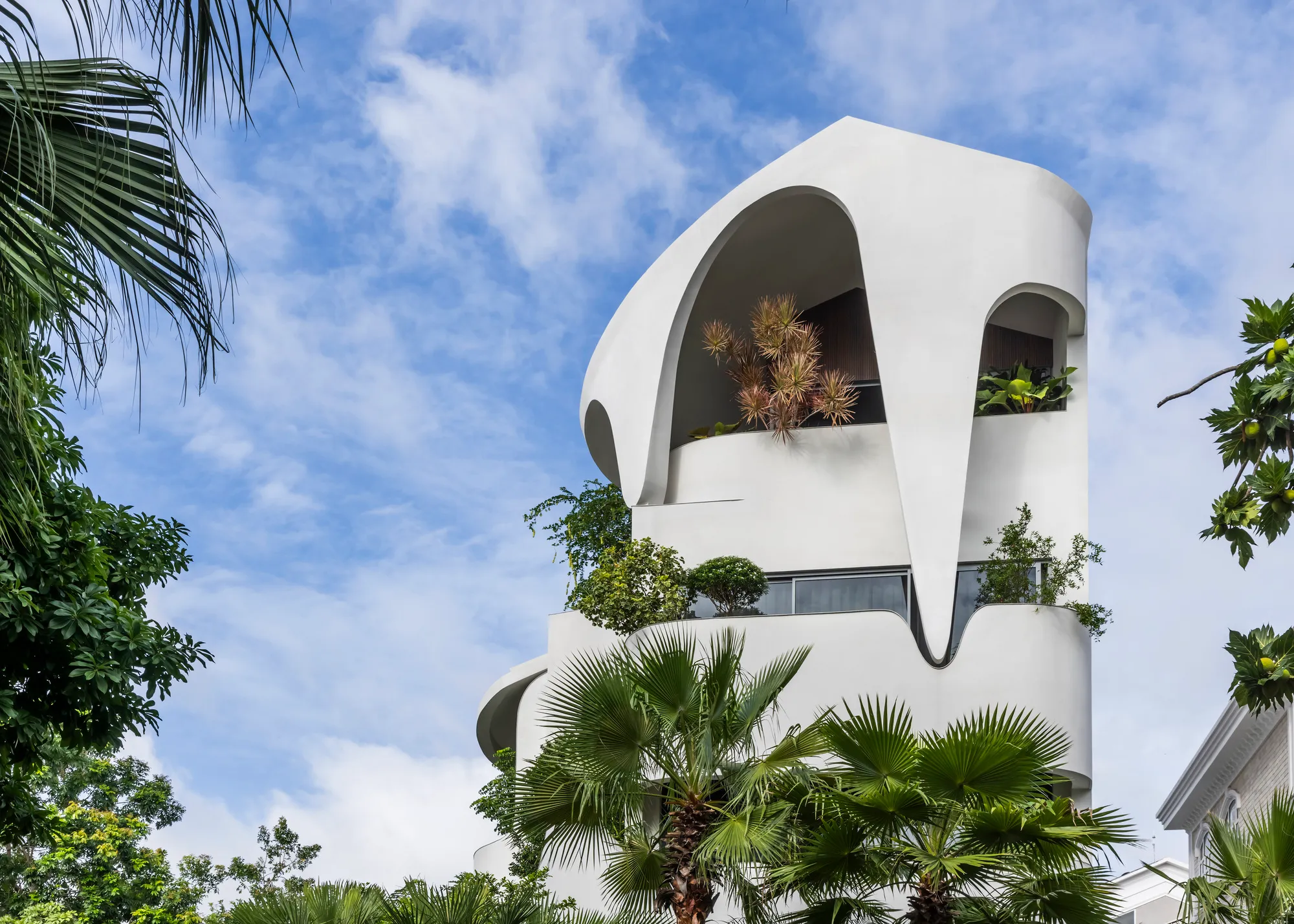 23o5Studio Wraps a Six-Bedroom Ho Chi Minh City Home in Curving White Terraces and Tropical Greenery