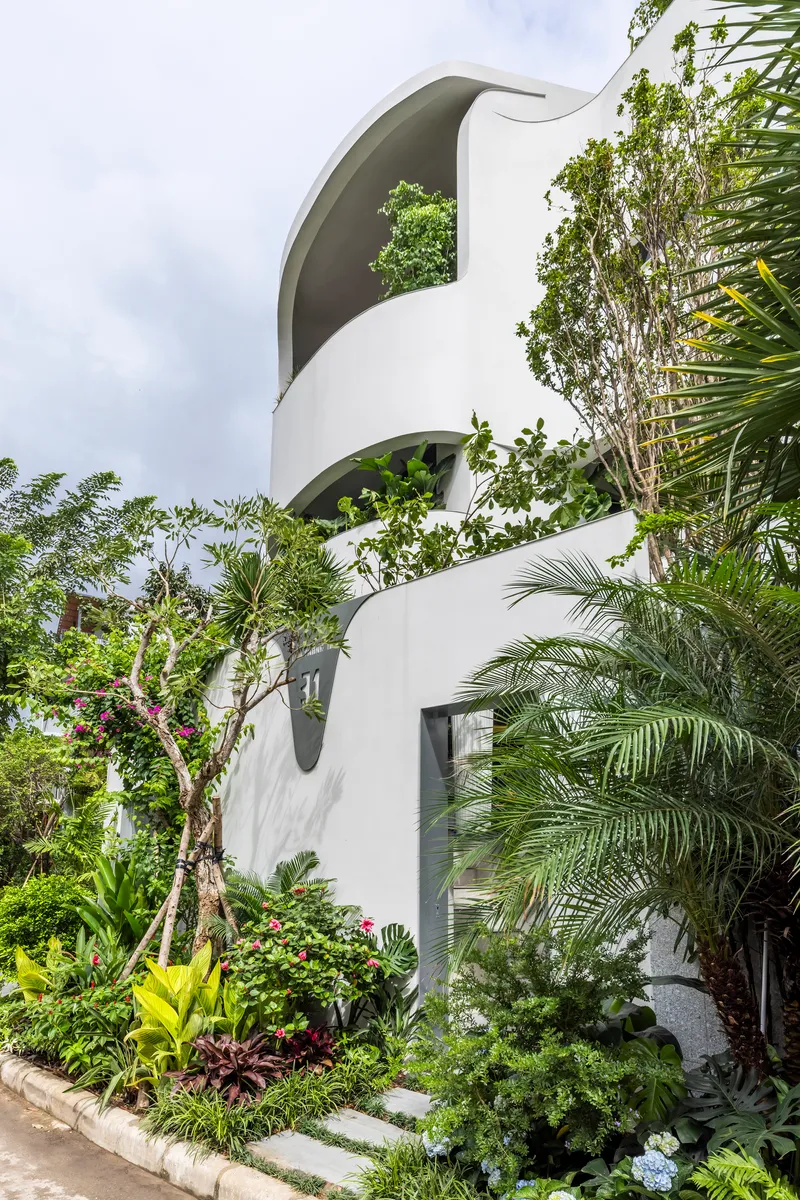 Stacked curving terraces with arched openings surrounded by tropical planting and palm fronds