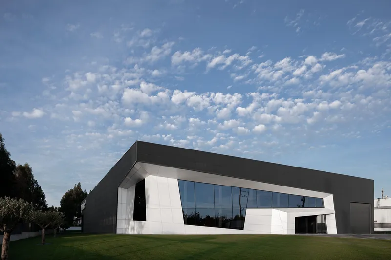 Horizontal massing softened by expansive glazing and landscaped foreground.
