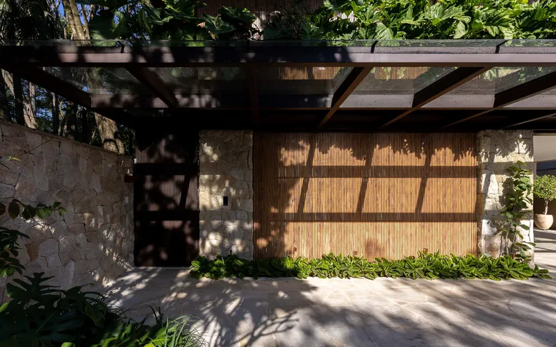 Timber slat screen wall casting dappled shadows beneath the pergola beams and planted green roof