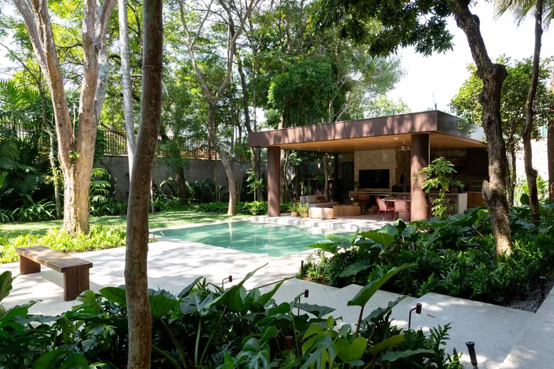 Pool terrace and covered pavilion nestled within preserved woodland and tropical understory plantings