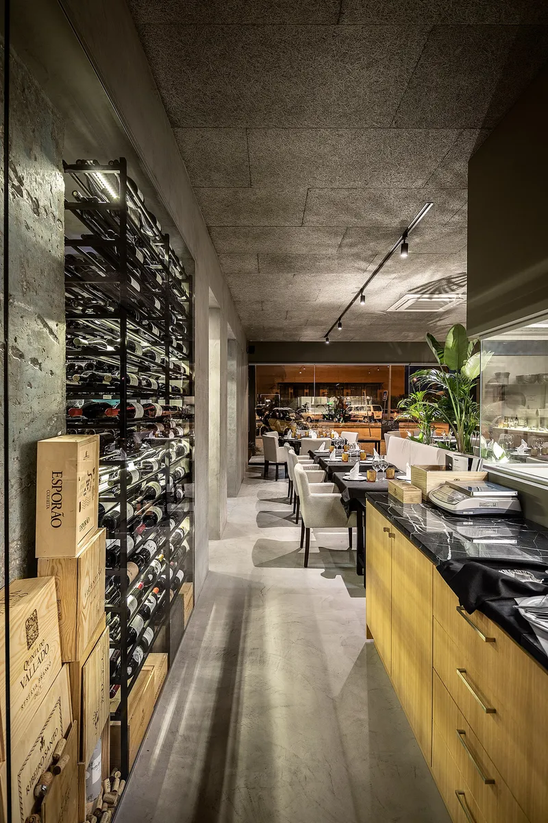 Bar and dining zones merge through material continuity and controlled ambient lighting.