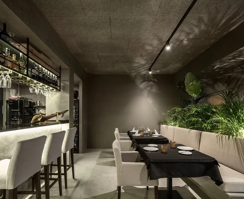 Vegetation introduces softness, creating privacy and acoustic buffering within the dining layout.