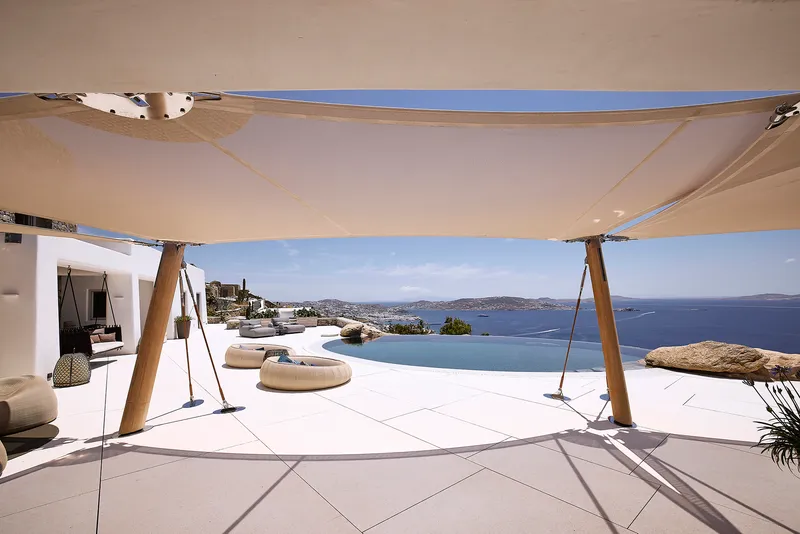 Terrace deck with tensile fabric canopy supported by timber posts overlooking the coastal landscape