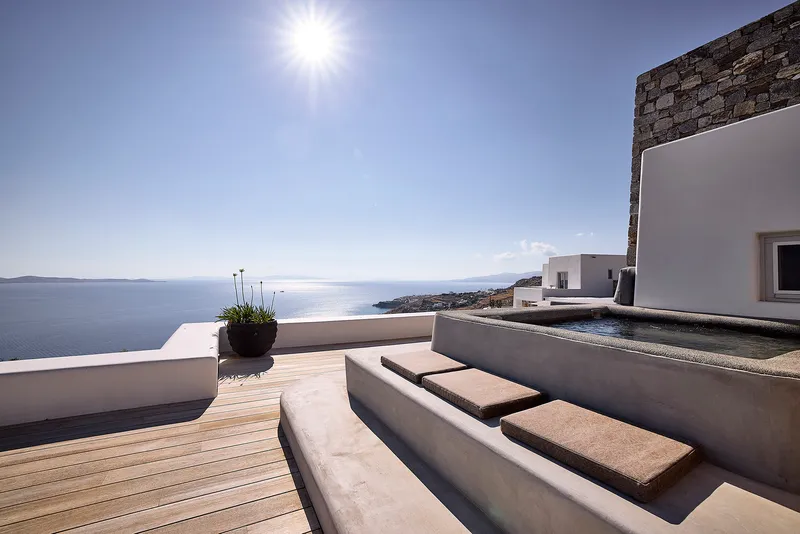 Concrete steps descending from timber deck to pool terrace at sunset