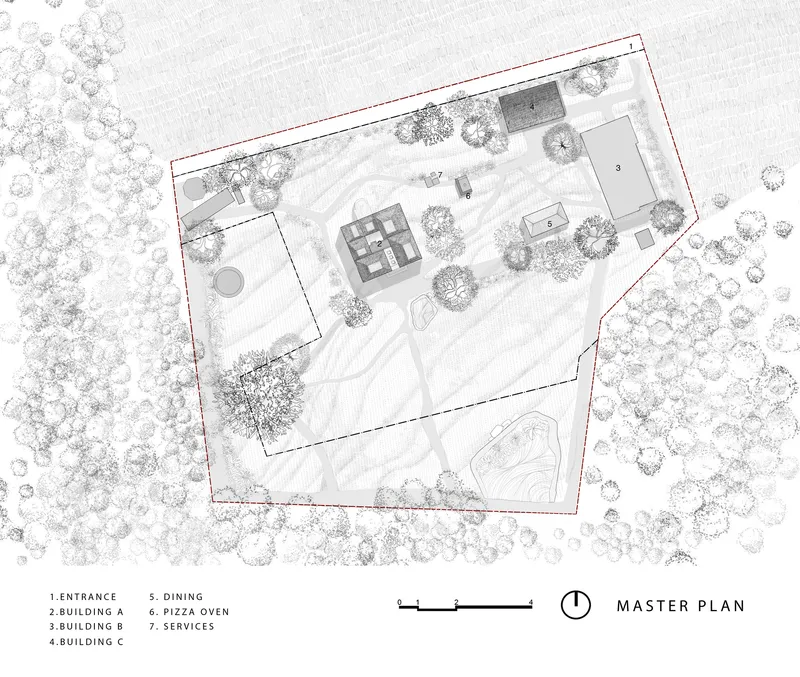 Site plan drawing showing multiple buildings and pathways within an irregular property boundary surrounded by trees