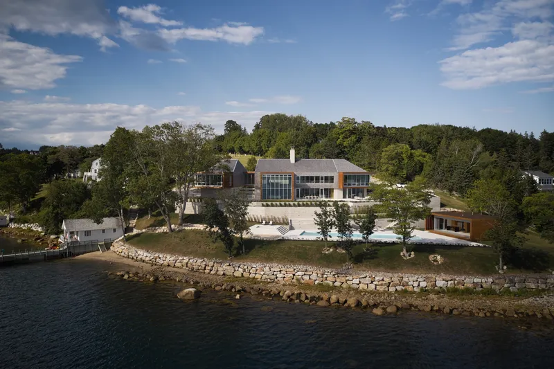 Aerial view of the compound on a rocky peninsula with glass facades and terraced stone walls