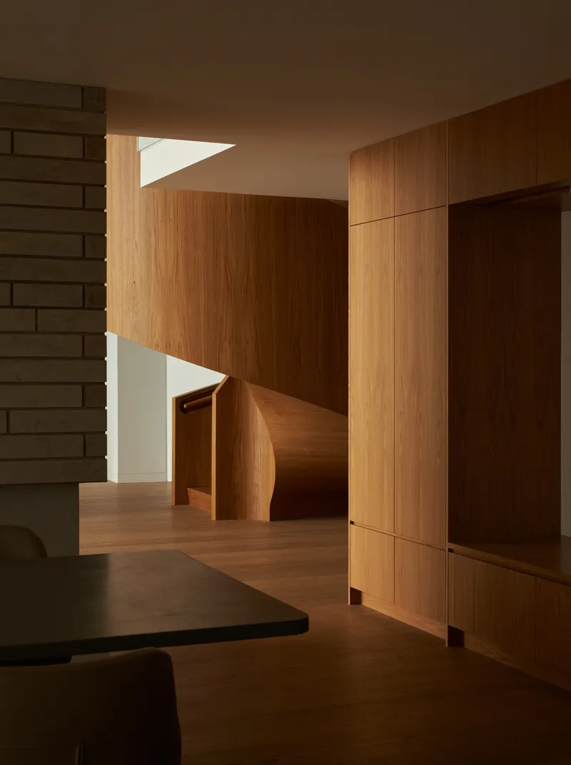Interior view showing timber-clad walls and curved staircase with skylight above