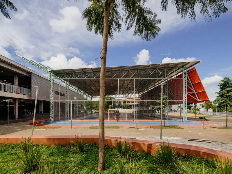Central courtyard enclosed by the steel truss canopy with palm trees and planting beds framing the view