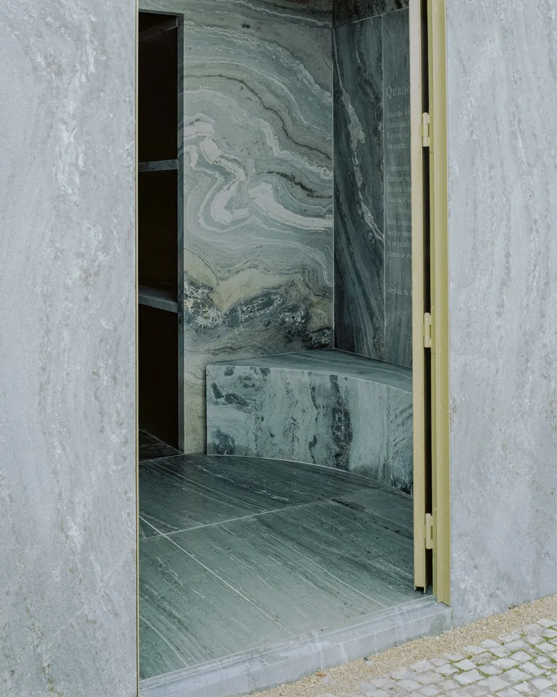 Threshold view into the marble-lined interior with veined stone walls and brass door edge