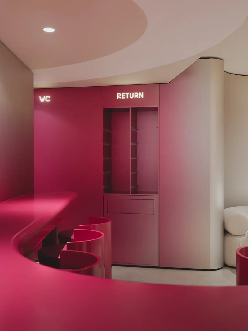 Return station with burgundy millwork, integrated storage cubbies and matching upholstered bench