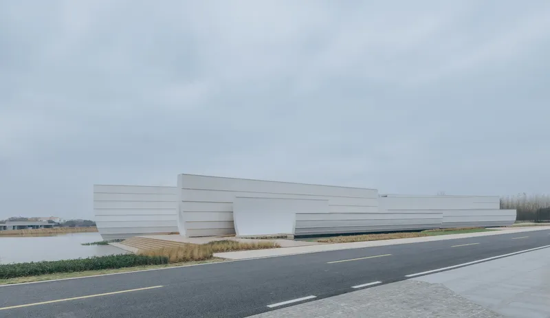 Roadside view of the horizontal striped white volume alongside grasses and water