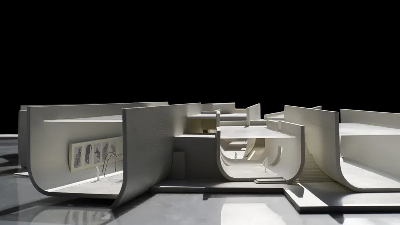 Sectional physical model exposing curved interior spaces with sunken amphitheater and terraced levels