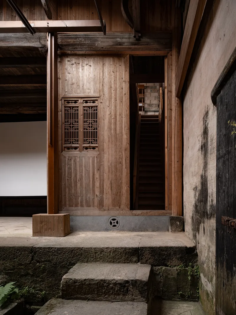 Timber door with latticed panels beneath exposed wooden beams and stone threshold steps
