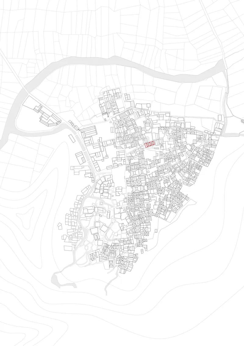 Site plan drawing showing dense urban fabric with a highlighted building near a river bend
