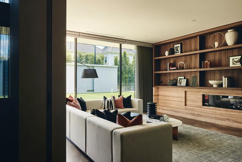 Living area with timber shelving wall and sliding glass doors opening to a lawn