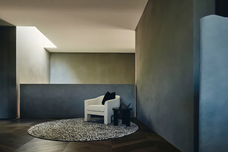 Seating nook with patterned circular rug beneath polished plaster walls