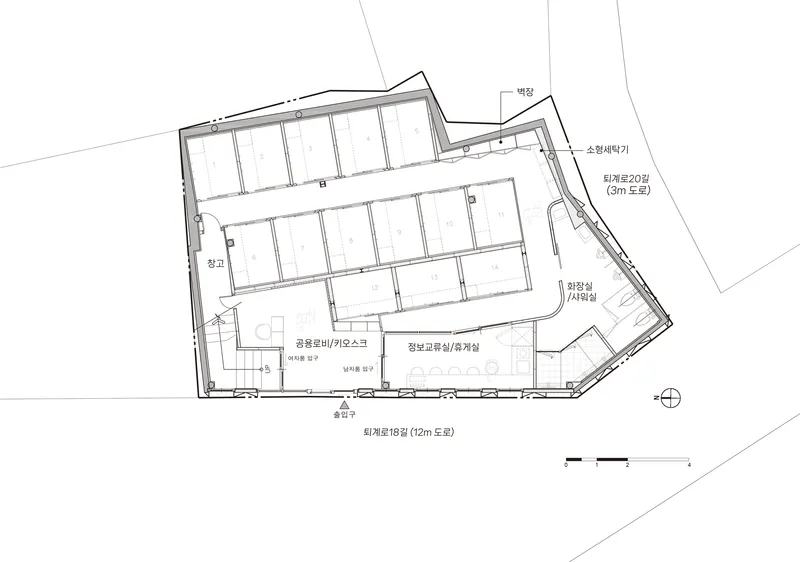 Floor plan drawing showing an angled perimeter with central corridor and cellular rooms
