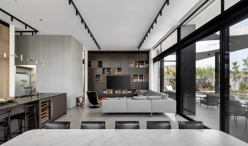 Open plan living space with built-in shelving and sliding glass doors opening to the garden