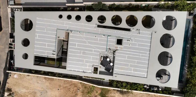 Overhead view of the white roof deck punctuated by circular openings of varying diameters