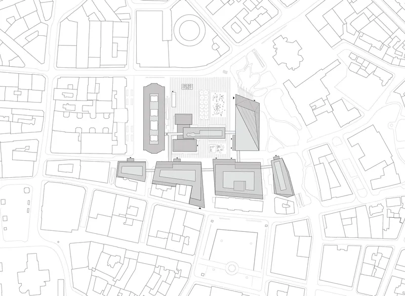 Site plan drawing showing clustered buildings with varied roof geometries within an urban block