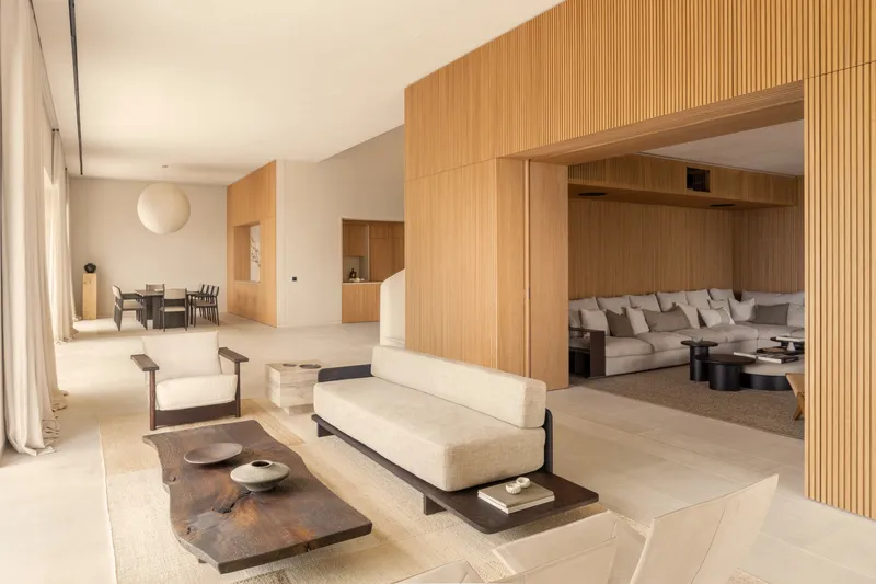 Open living room with timber slat wall framing a recessed seating alcove in soft daylight