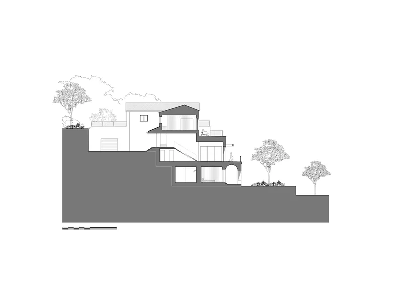 Section drawing showing split-level volumes descending the hillside with an arched opening below