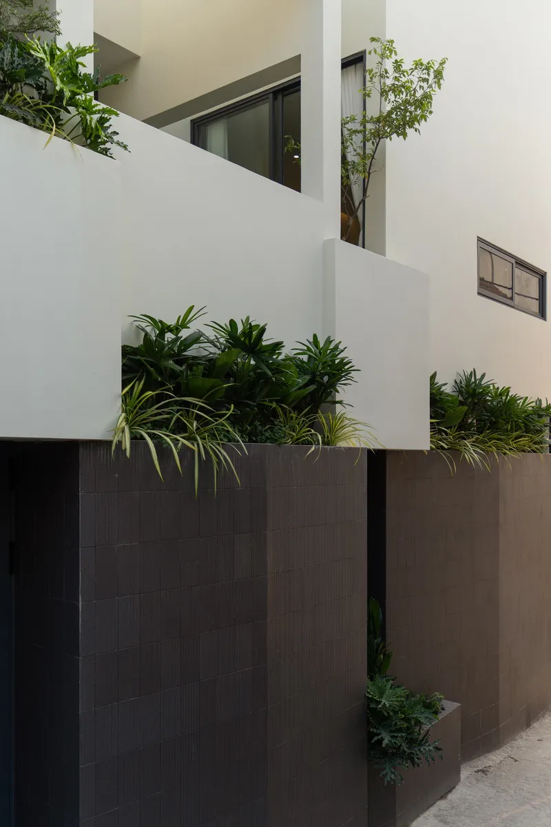 Close-up of the staggered white volumes with planted terraces and horizontal window openings