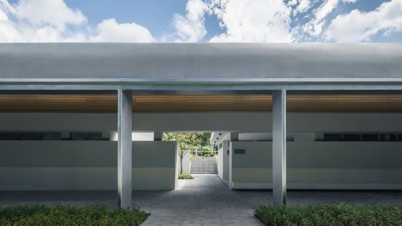 Central passage beneath three concrete barrel vaults with timber soffit panels and clerestory glazing