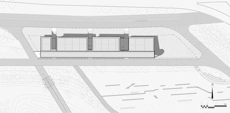 Site plan showing a linear building with three connected volumes and surrounding landscape features