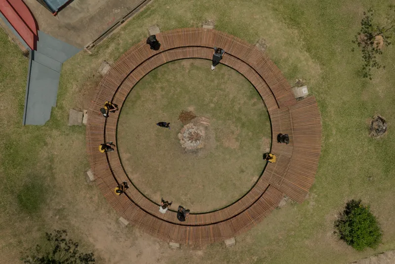 Aerial view of the ring-shaped timber deck with visitors seated on benches around the perimeter