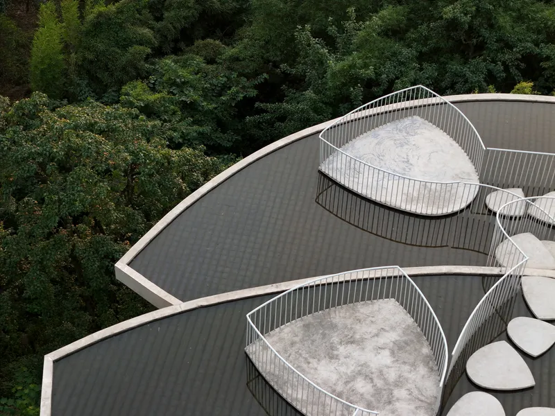 Aerial view of two curved roof terraces with white metal railings and petal-shaped decks