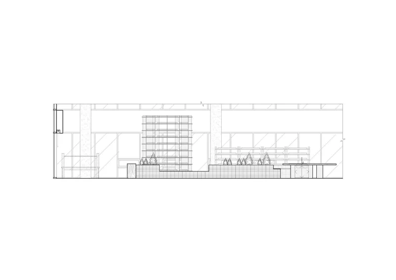 Section drawing showing tiered seating area beneath gridded ceiling and transparent wall system