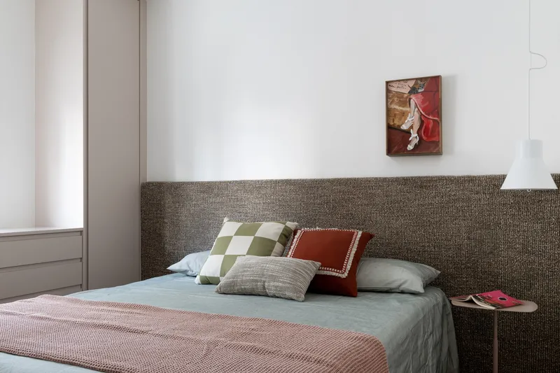 Bedroom with textured headboard wall and pendant light beside the bed