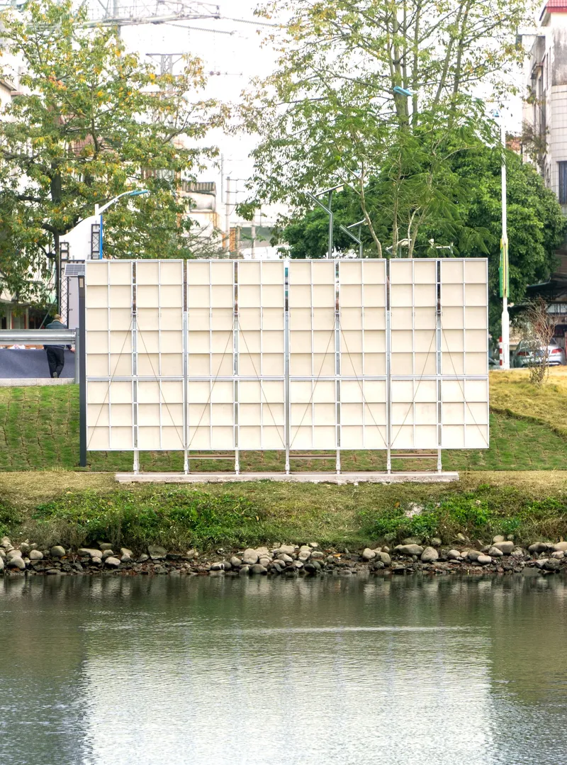 Freestanding grid wall with white steel frame and translucent panels facing the waterfront