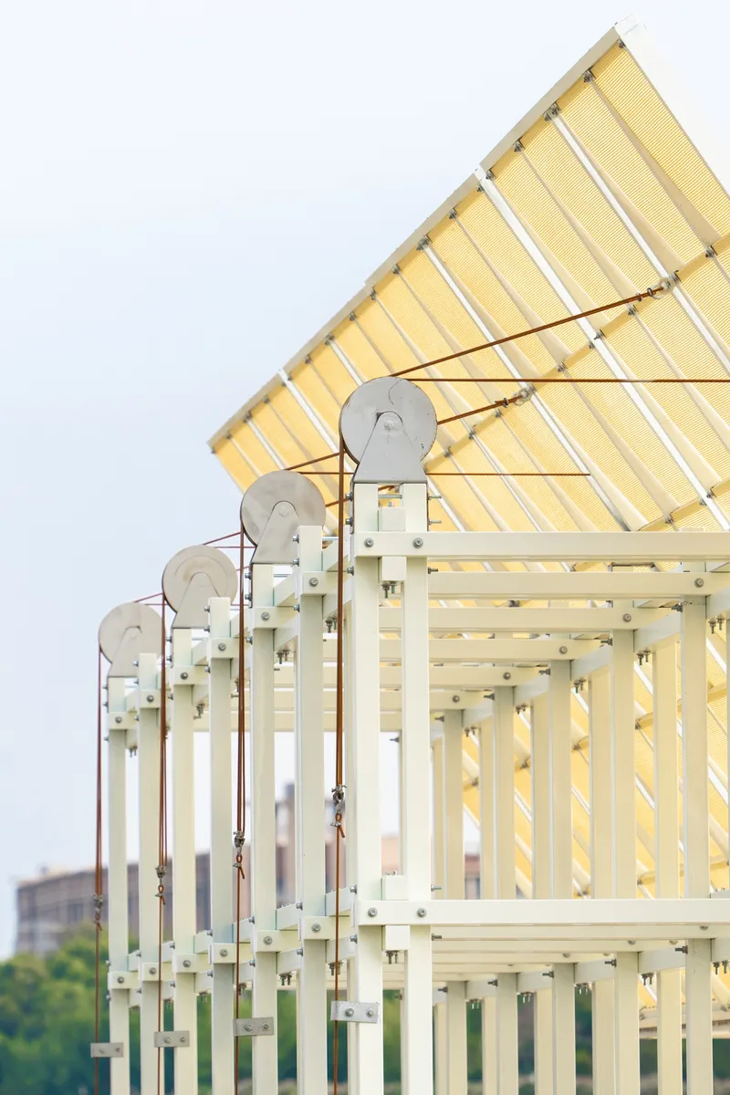 Detail of the gabled roof corner showing pulley mechanisms and white steel frame members