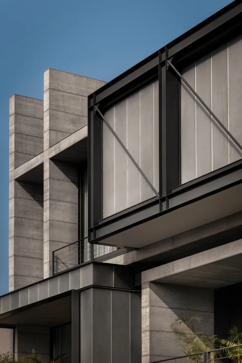 Detail of board-formed concrete columns and diagonal braced glass panels at stacked floor levels